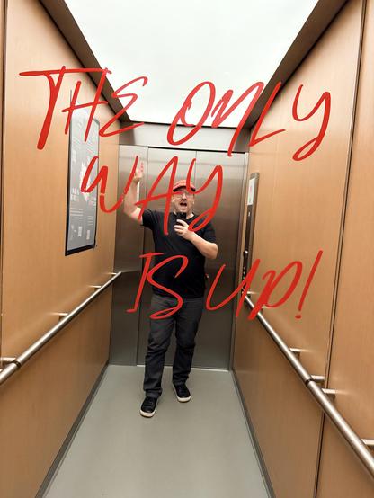Boris is taking a mirror selfie in an elevator.
It says “The Only Way Is Up!”