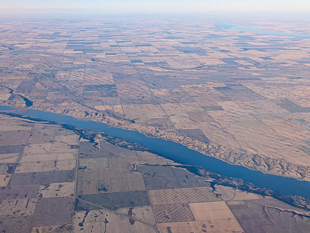 Aerial picture of a long skinny lake cutting across the Prairies.