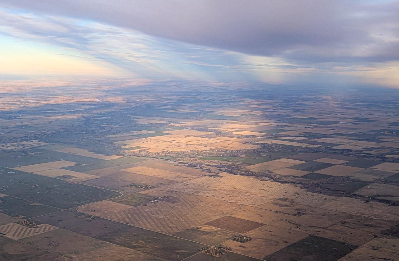 Aerial photo of partial sun on the Prairies through clouds.