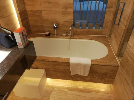a luxury bathtub with a marble surround and ambient accent lighting