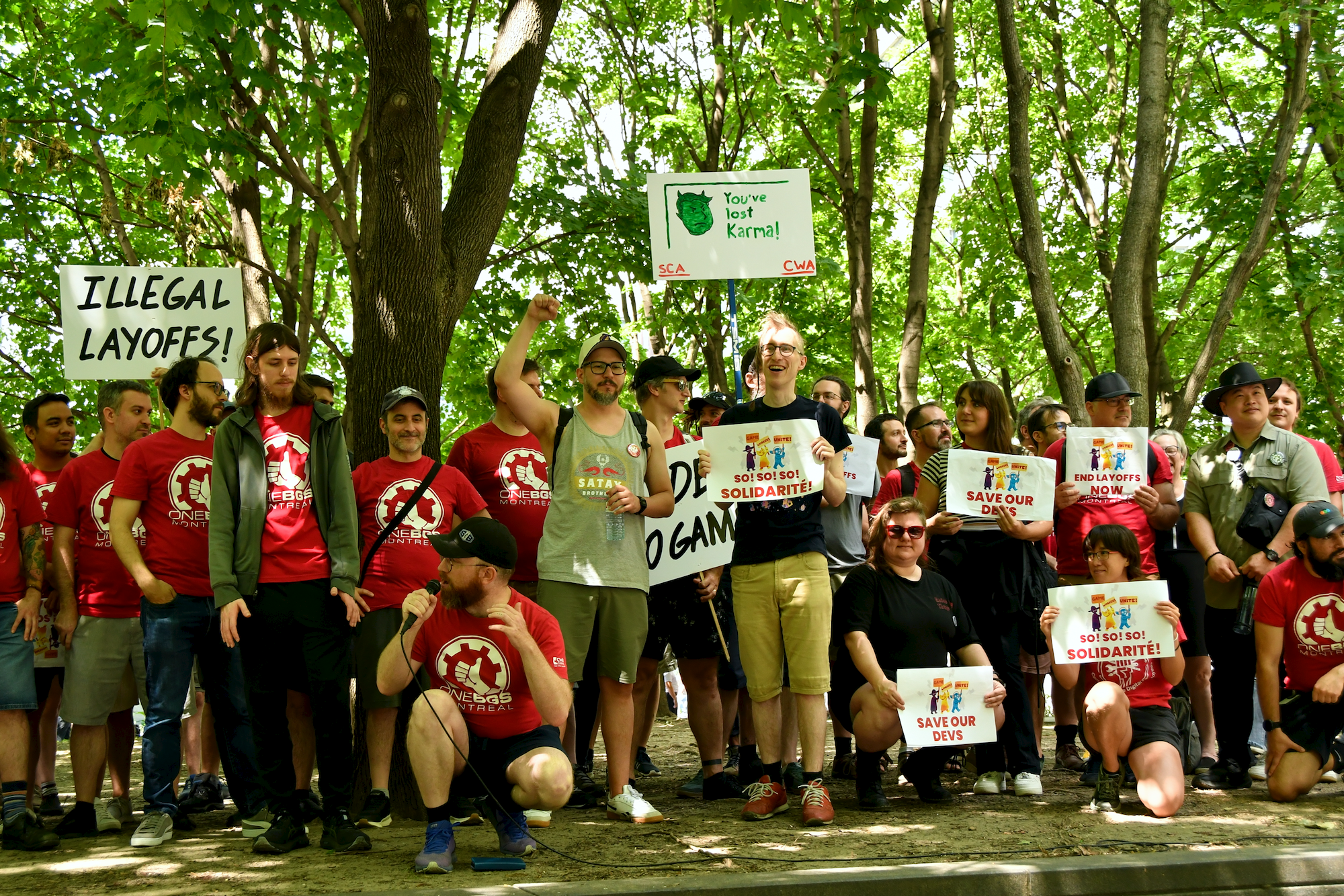 Photo du groupe posant avec leurs pancartes et chandails rouge
